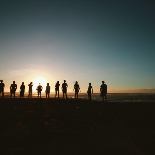 Silhouette of people standing in the sunset